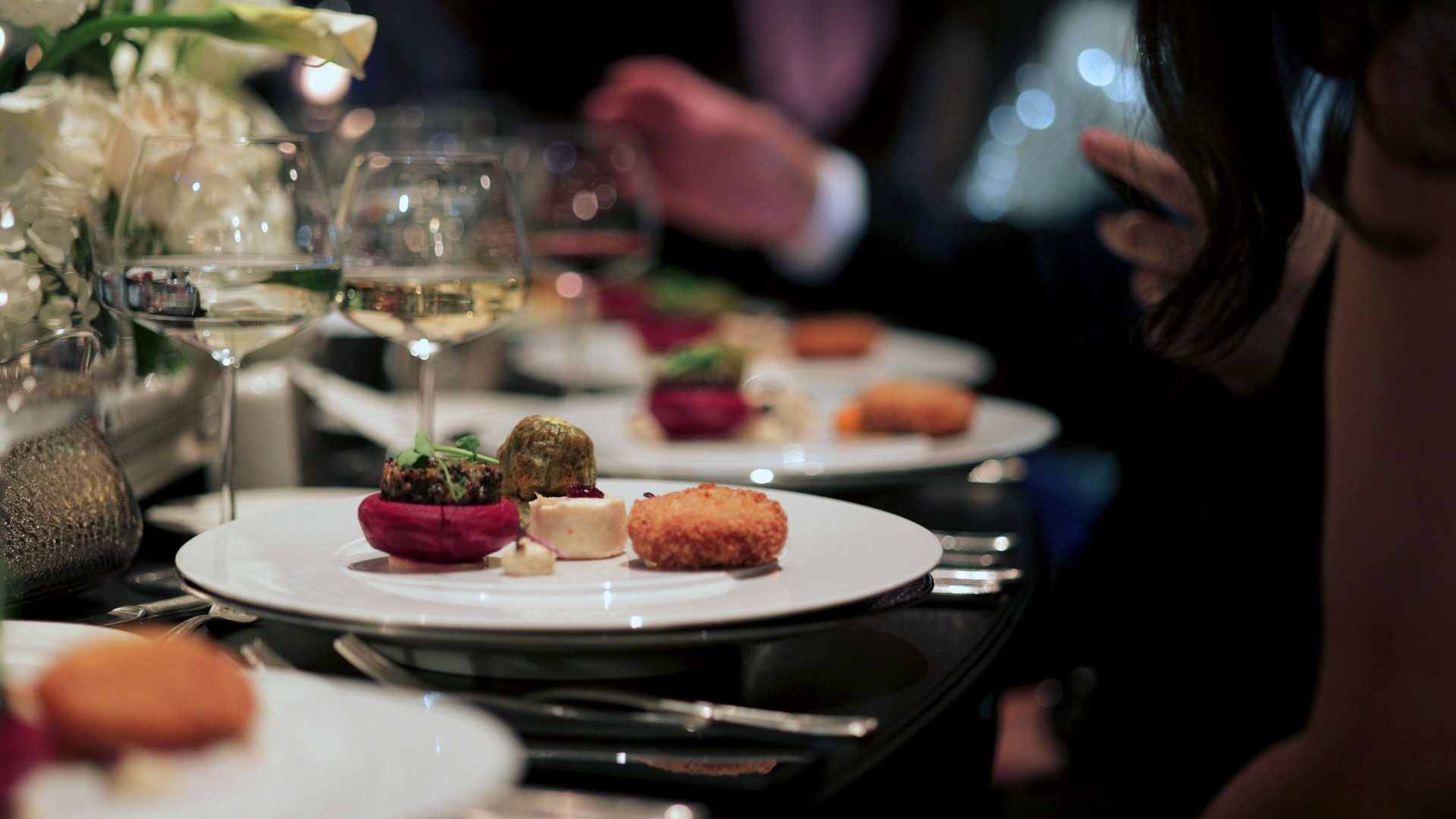 Elegant Fine Dining Experience at a Luxury Event. A beautifully plated dinner set on a luxurious table.