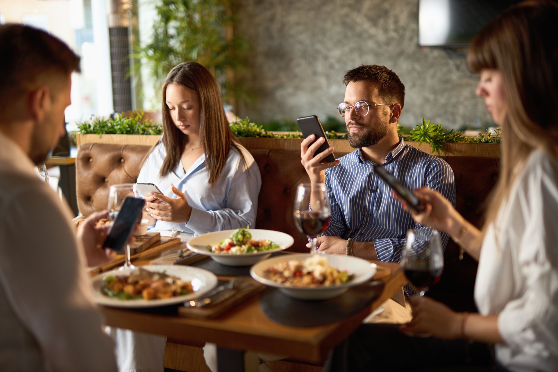 Young entrepreneurs with their cellphones sitting in cafe